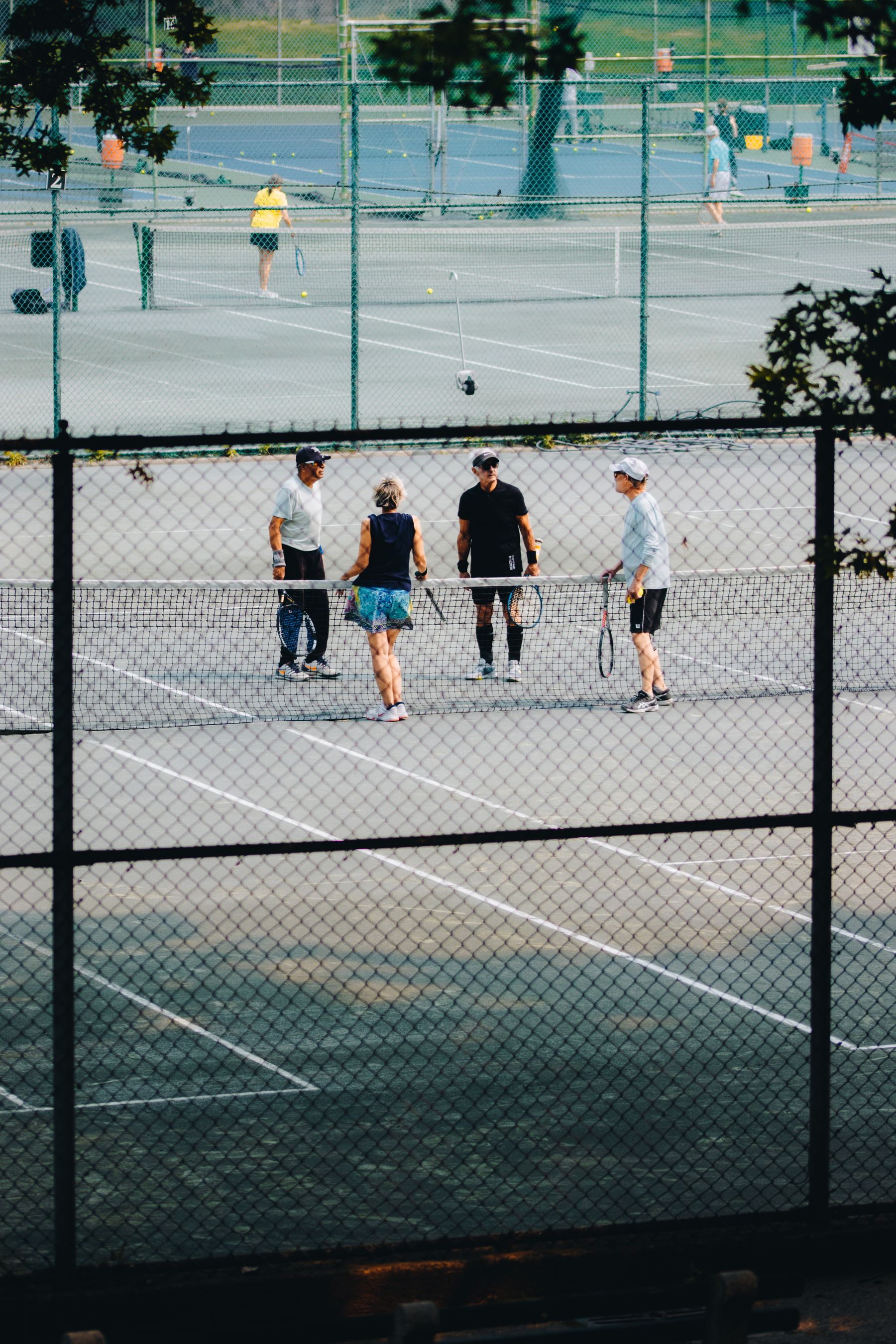 A group of players talking together at a tennis court
