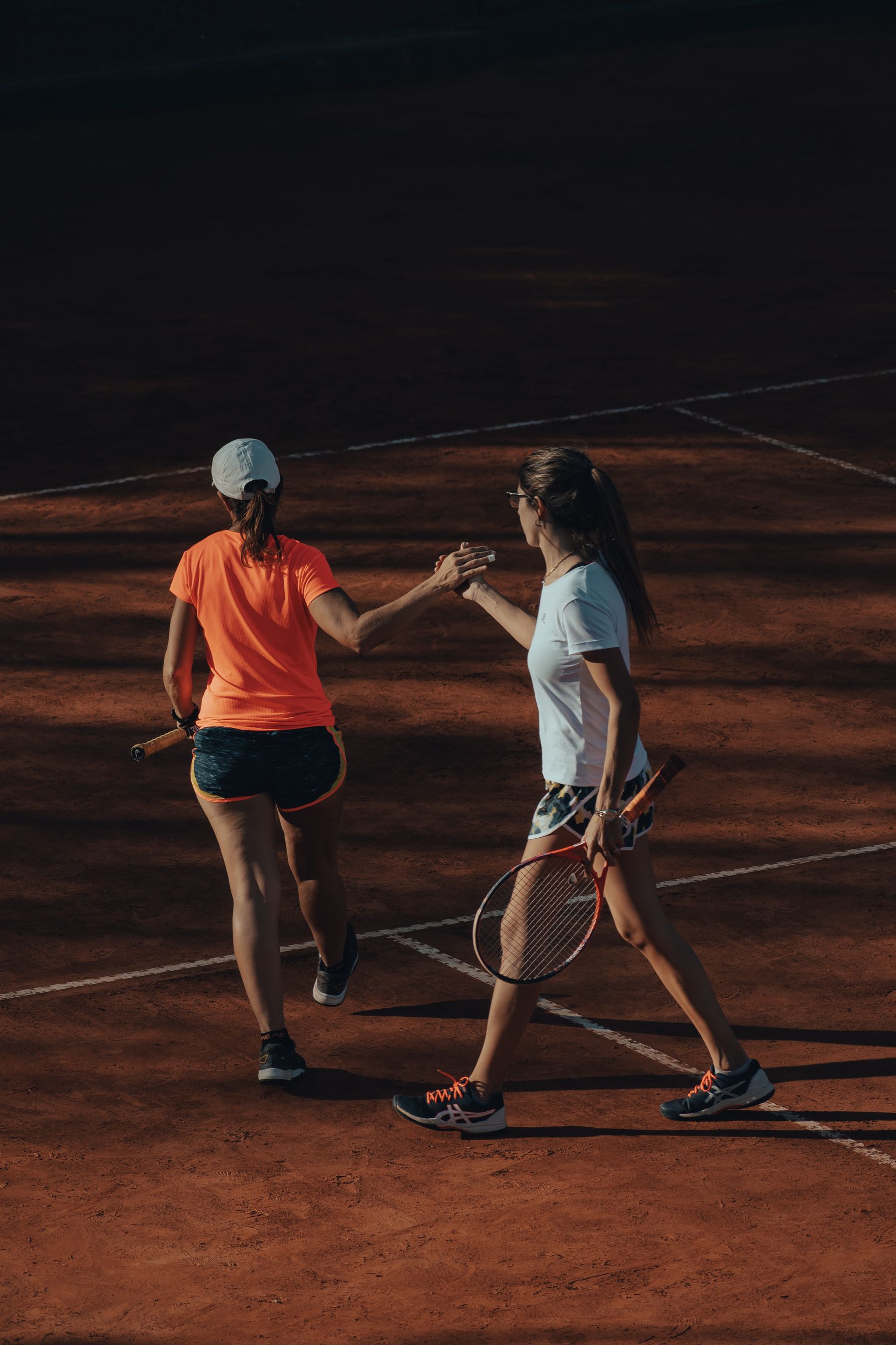 Two tennis players greeting each other after a match